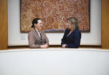 two women in front of art
